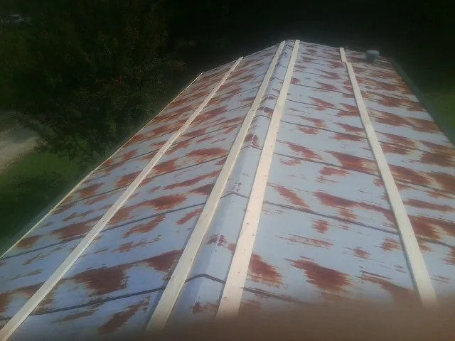Rusted metal roof panels with new wood purlins before replacement — Storm Damage Roof Repair in Emington by Roofing Brothers