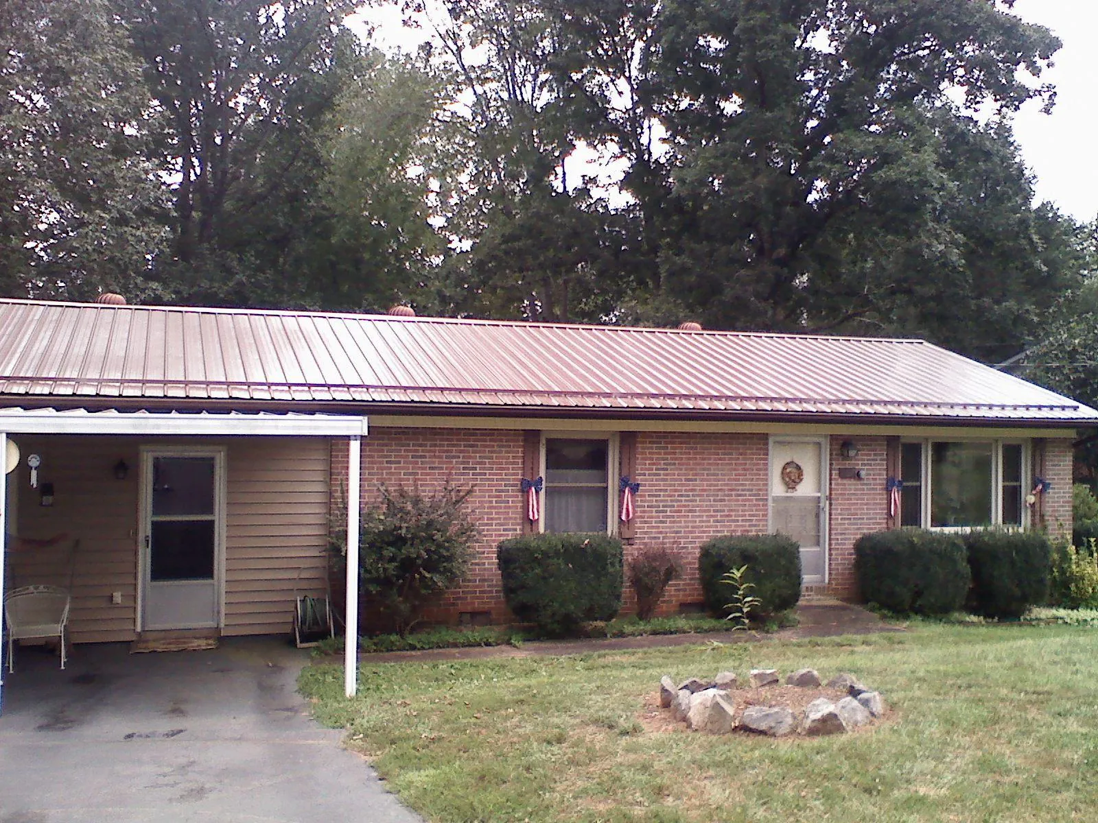Bronze metal roof and carport on a brick ranch home — Roof Repair work by our crew in Emington