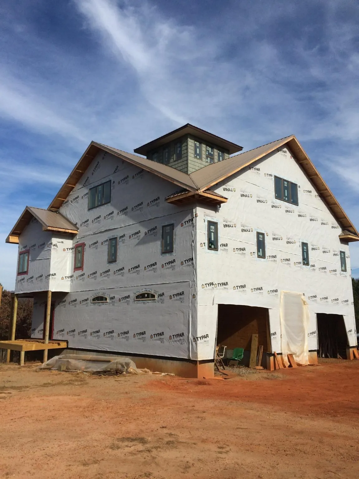 New two story house under construction with a cupola and gabled roofs in Emington